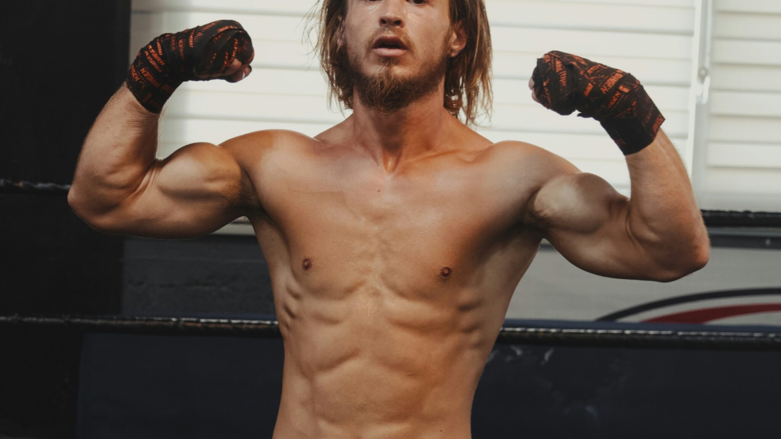 A shirtless man standing in a boxing ring