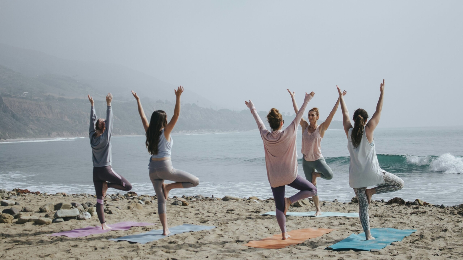five woman standing on seashore